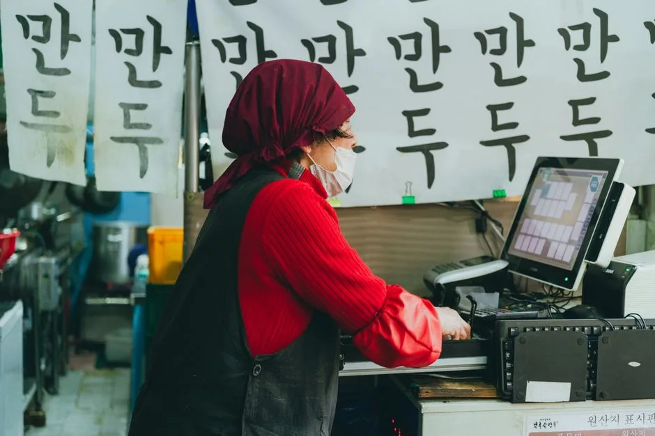 한국 시장에서 포스기를 사용하는 만두가게 사장님